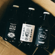 Load image into Gallery viewer, Image of 3 cold brew growlers. One with a white label featuring the skeleton of a left hand, and 2 with black labels with different variations of Left Hand and Cold Brew writings.
